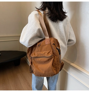 Close-up of caramel brown nylon backpack showing large capacity and side texture