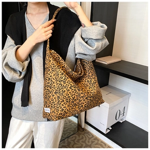 Detail of large leopard print tote bag with woven chic label shown on model for daily styling
