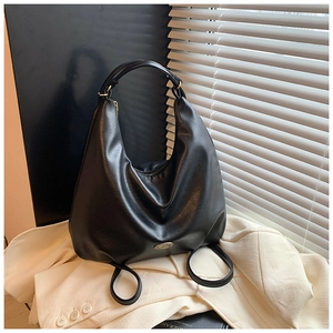 Close-up of black leather hobo bag with litchi texture and gold brand logo