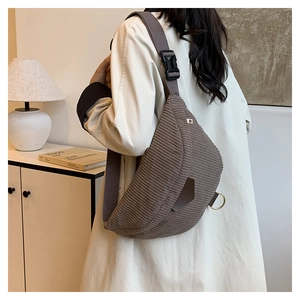 Détail d'un sac bandoulière en velours côtelé marron foncé avec sangle large ajustable