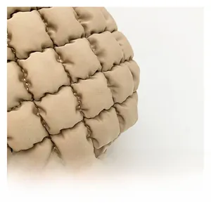 Detail shot of beige quilted bubble fabric showing soft texture and fine stitching work