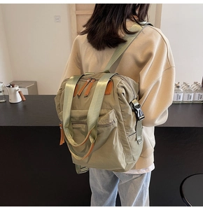 Olive green versatile backpack worn by a person, showing multi-pocket design and nylon texture