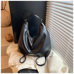 Detail of black crescent hobo bag with gold zipper and handmade metal plate detail