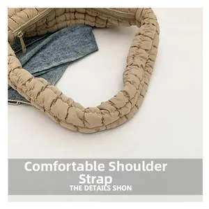 Detailed close-up showing the comfortable pleated shoulder strap and fine stitching of the beige bag