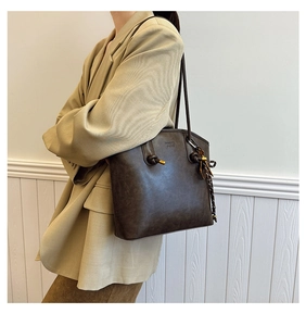 Detail of vintage brown tote bag showing the knot handle design and smooth leather texture