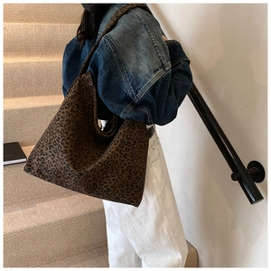 Spacious leopard print canvas tote bag shown on model with wide shoulder straps