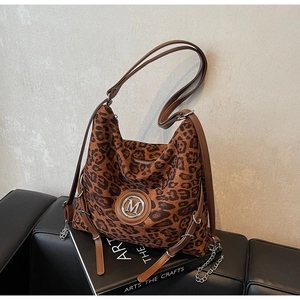 Detailaufnahme der Leoparden-Tote-Bag mit silbernem M-Logo und Leder-Schultergurt