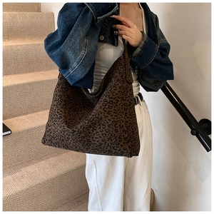 Detail of the large leopard print tote bag fabric and texture on model shoulder