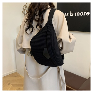 Détail du sac bandoulière en velours côtelé noir avec sangle réglable et boucle sur modèle