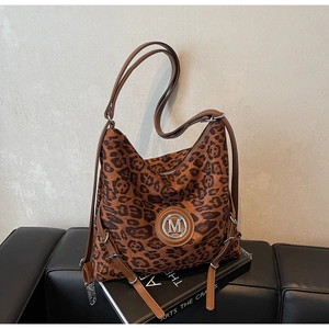Detail der Leopard-Print Shopper mit silbernem M-Logo und Ketten-Dekor auf Ledersitz