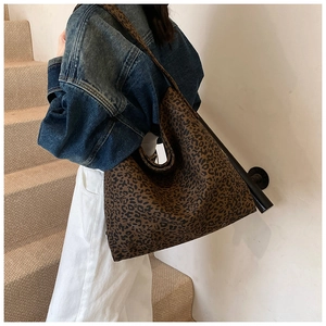 Detail shot of a large leopard print canvas tote bag styled with casual denim attire