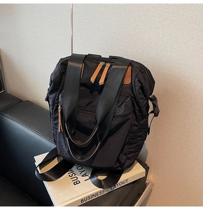 Detail of black nylon backpack with brown zipper pulls on a business display box