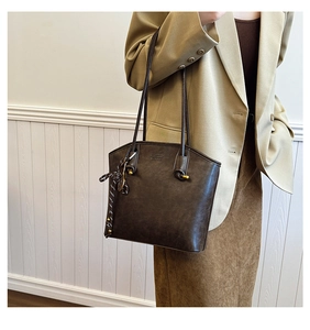 Detail showing vintage dark brown tote bag texture with elegant scarf and brand logo