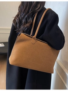 Minimalist brown suede tote bag with long shoulder straps shown in professional model shot