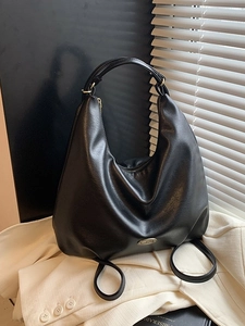 Classic black PU leather hobo tote bag with gold zipper on a beige blazer background