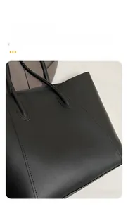 Detail of reinforced handle stitching and textured black leather on large tote bag