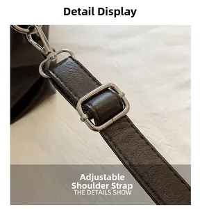 Detail of adjustable strap with silver buckle on brown vintage tote bag
