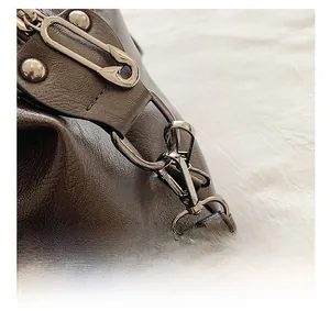 Detail of vintage brown pebble leather tote bag with unique safety pin zipper hardware