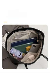 Interior view of black tote bag showing organized compartments with various daily essentials