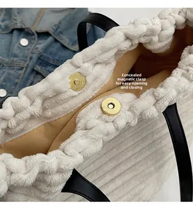 Detail of the hidden magnetic snap closure on the beige corduroy tote bag