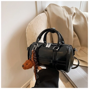 Détail du sac Boston noir avec zip argenté et breloque en peluche pour chien