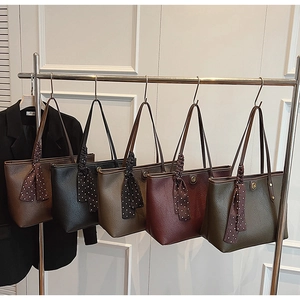 Detail view of five textured tote bags with polka dot scarves and gold hardware