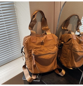Close-up of caramel brown multifunctional backpack with large zipper pocket and wide handle