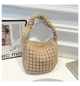 Detalle del bolso de cubo acolchado beige en nailon texturizado con cierre de cremallera