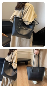 Close-up of black PU leather tote bag with front zipper pocket and decorative stitching