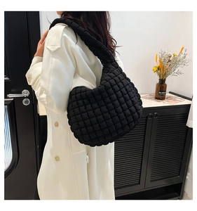 Detail of black quilted cloud bag with puffy texture on a casual shoulder bag for women