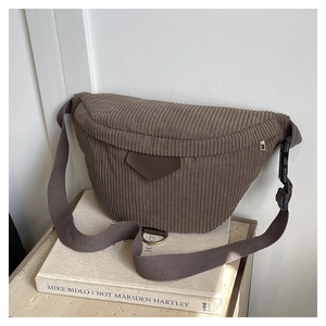 Close-up of dark brown corduroy waist bag with textured fabric and metallic D-ring detail