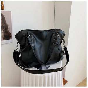 Detail of black large capacity tote bag featuring soft pleated texture and silver rivets