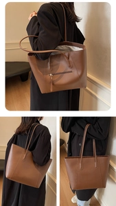 Detail of a large brown leather tote bag showing the back zipper pocket and handle
