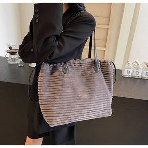 Detail of coffee brown corduroy tote bag showing textured fabric and black PU leather strap