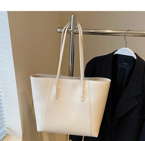 Detail of a large cream PU leather tote bag with long straps for versatile daily use