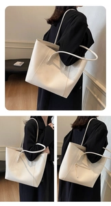 Detail of white tote bag showing a sleek back zipper pocket on matte leather finish