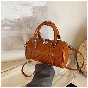 Vue détaillée d'un sac Boston vintage marron avec double fermeture éclair et texture cirée