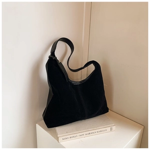 Détail du grand cabas noir mat minimaliste avec des anses en cuir sur un bureau blanc