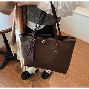 Detail of coffee brown tote bag with leather texture, DM logo and decorative silk scarf