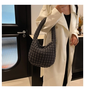 Close-up of charcoal grey quilted bucket bag with soft pleated texture on shoulder