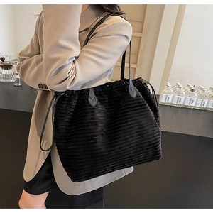 Close-up of black corduroy tote bag featuring striped texture and drawstring closure