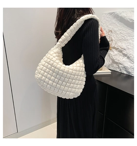 Detailed view of white quilted puffer shoulder bag with a cloud-like pleated texture