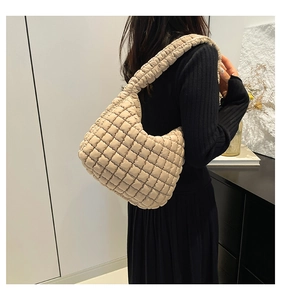 Detail of beige quilted shoulder bag made of lightweight nylon with soft square patterns