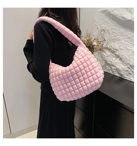 Detail view of pink quilted bucket bag with textured bubble fabric and wide shoulder strap