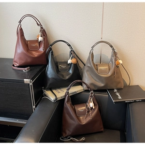 Detail view of large leather tote bags in four colors with chain straps and tassel charms