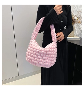 Detail of pink quilted puff bag showing soft ruched fabric texture on a model