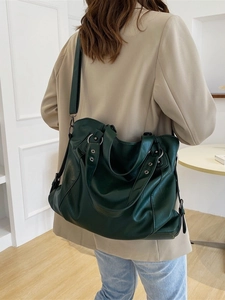 Forest green large capacity faux leather tote bag shown on model with shoulder strap