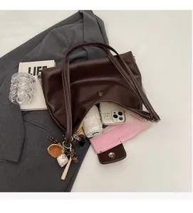 Detail of dark brown leather tote bag with contrast stitching and large interior capacity