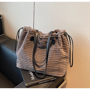 Detail of coffee corduroy tote bag with vertical texture and thin black shoulder straps