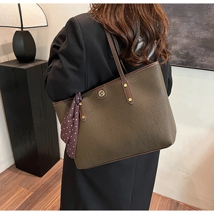 Olive green tote bag detail showing lychee grain leather and silk scarf handle